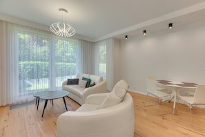En moderne stue med en sofa, et spisebord og en loftlampe.