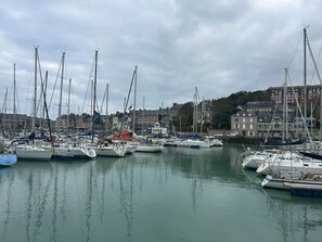 A marina with multiple boats docked, buildings in the background, and calm water. - Tevenn Bras : Maison chaleureuse pour séjour détente entre mer et campagne (Sotteville-sur-Mer)