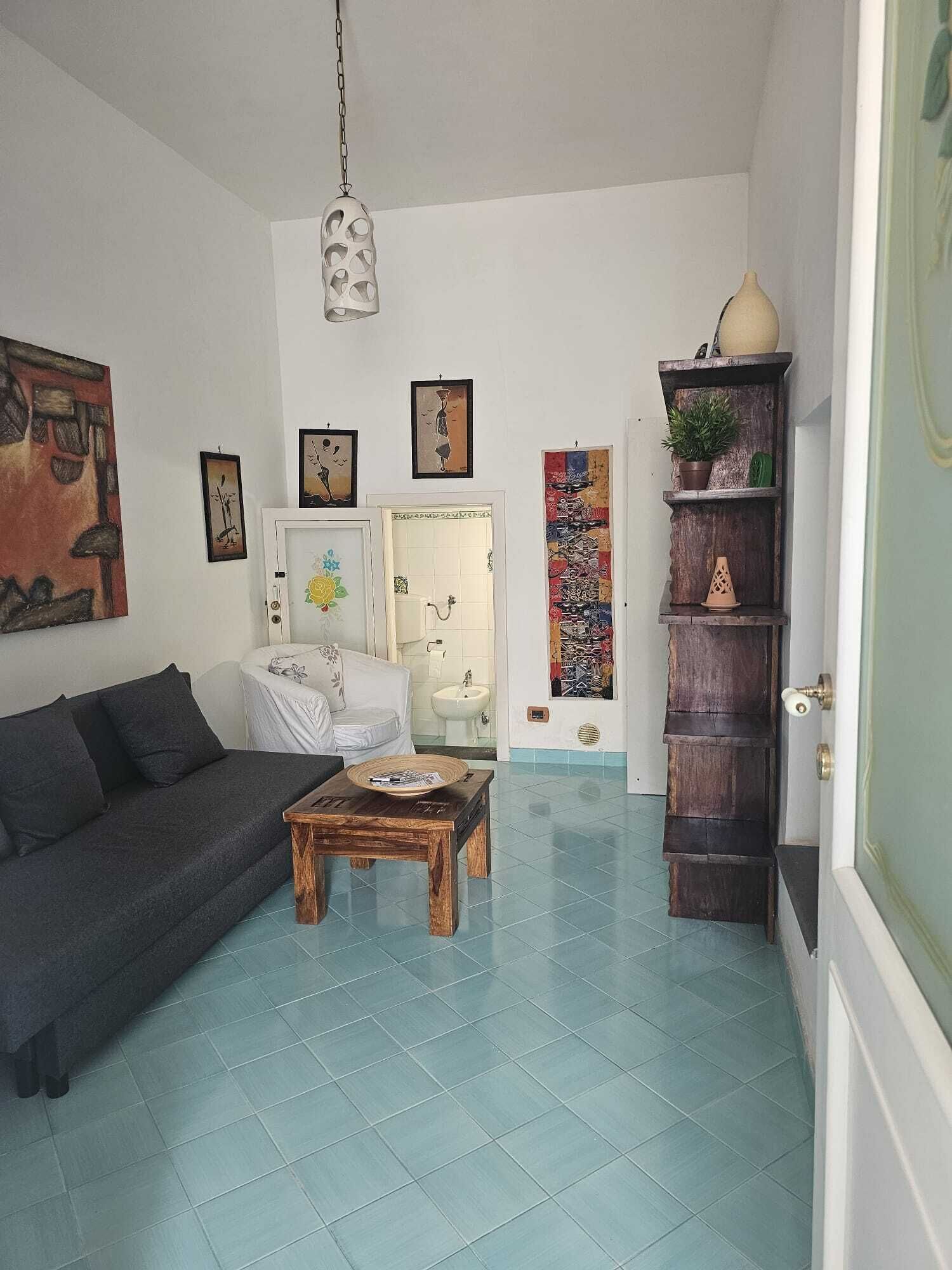 Un salon avec un canapé, une table basse et des œuvres d’art accrochées aux murs.