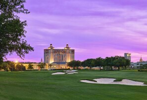 A large hotel with multiple towers, a well-maintained lawn, and sand bunkers. - Retreat at Savannah Harbor 30+ Night Stay (Savannah)