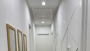 Ein Korridor mit Holzboden, weißen Wänden und einer Tür am Ende.