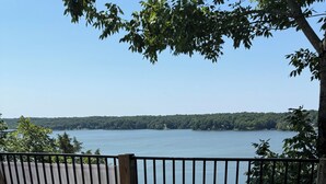 A wooden deck with a view of a lake, a chair, and a table. - Deer Run on Eddy Bay
4 bd , 3 bath luxury lake living! (Eddyville)