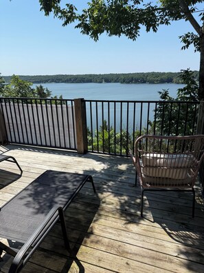 A wooden deck with a view of a lake, a chair, and a table. - Deer Run on Eddy Bay
4 bd , 3 bath luxury lake living! (Eddyville)
