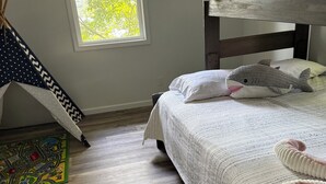 A bedroom with a bunk bed, a window with daylight, a star-patterned curtain, a map rug, and a plush shark toy. - Deer Run on Eddy Bay
4 bd , 3 bath luxury lake living! (Eddyville)