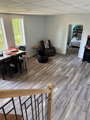 A room with a dining table, chairs, a massage chair, a bed, and a game console. - Deer Run on Eddy Bay
4 bd , 3 bath luxury lake living! (Eddyville)