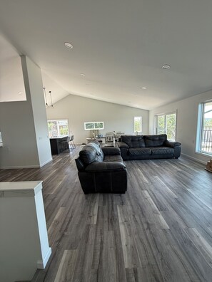 A spacious living area with a sectional sofa and a dining table, large windows, and a high ceiling. - Deer Run on Eddy Bay
4 bd , 3 bath luxury lake living! (Eddyville)