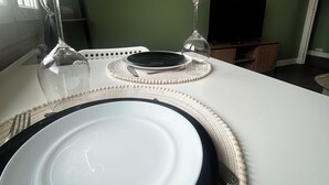 A dining table set with plates, glasses, and a placemat. - Charming, cosy T2 in the heart of Caen - Free parking (Caen)