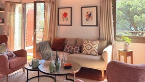 A cozy living room with a wooden ceiling, a sofa set, a coffee table, and a view through large windows. - Le Mas des 3 Frères - sea view - 200m walk to the beach - Domaine de l'Escalet (Ramatuelle)