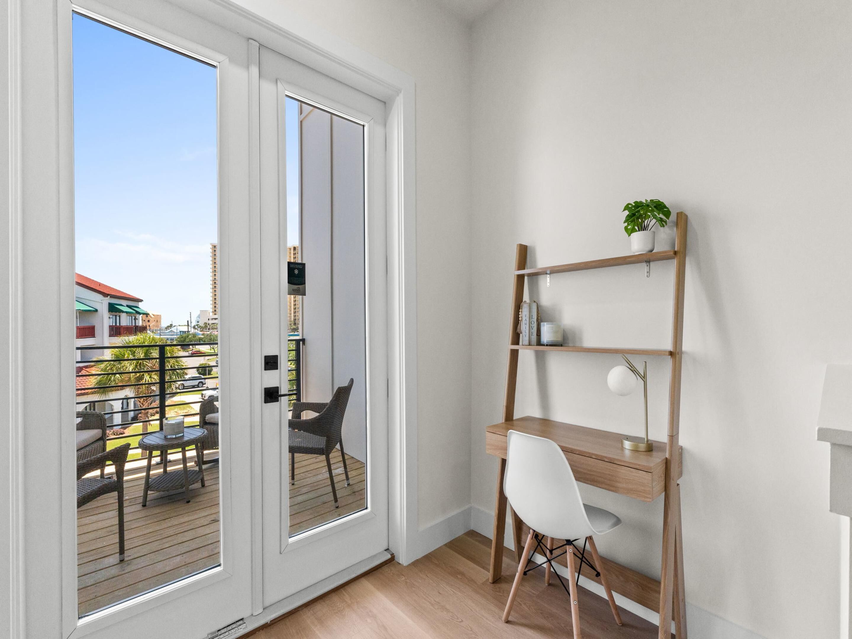 A room with a wooden desk, white chair, and a bookshelf.