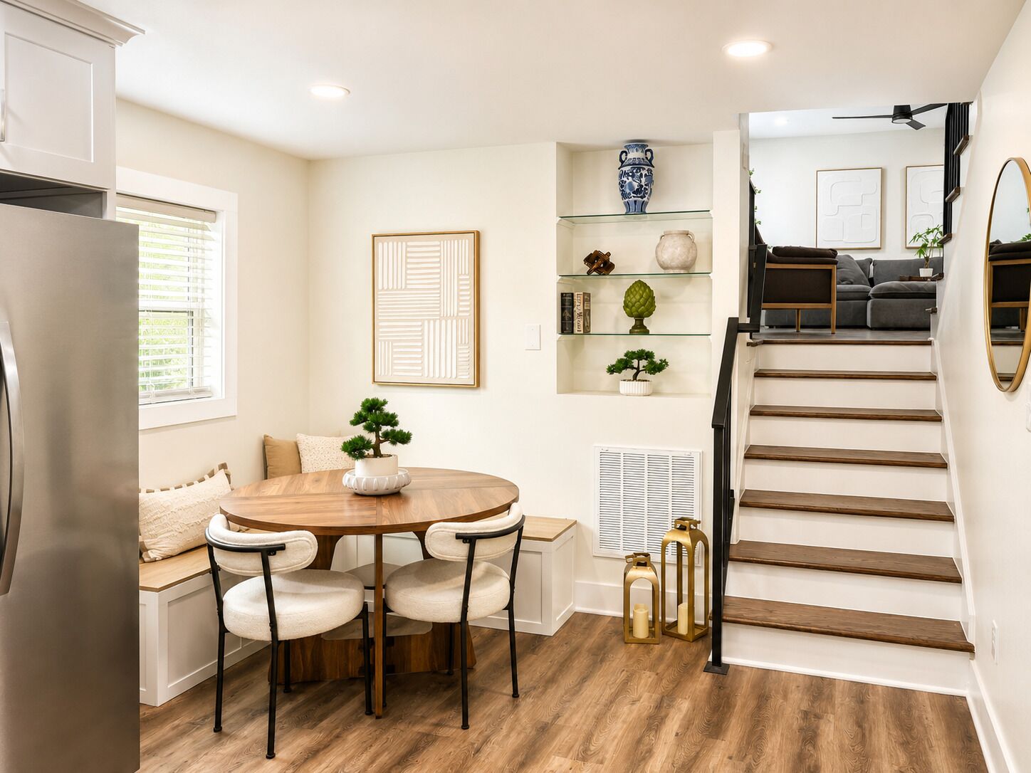 Una cocina moderna con comedor, una escalera y una sala de estar con sofá y mesa de centro.