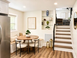 A modern kitchen with a dining area, a staircase, and a living room with a sofa and a coffee table. - Spacious 4-bedroom house near LoSo Charlotte with fenced backyard (Charlotte)