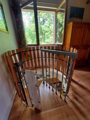 A room with a circular wooden structure, large windows with a view of greenery, and a wooden cabinet. - The 3 Pignons gourmet refuge (Noisy-sur-École)