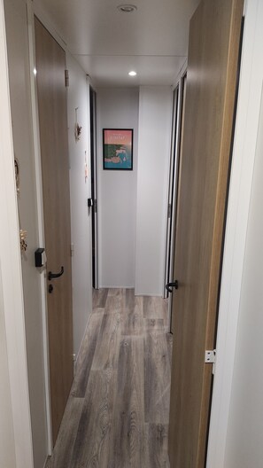 Ein Flur mit Holzboden, weißen Wänden und einem gerahmten Bild.