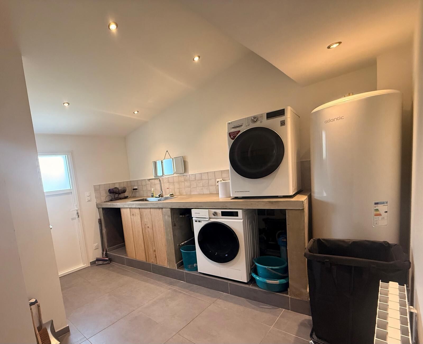 A laundry room with a washing machine, dryer, and stacked laundry baskets.