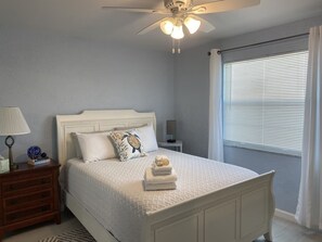 A bedroom with a bed, a nightstand, a lamp, a ceiling fan, and a window with blinds. - Beautiful 2-bedroom, 2-bath condo perfect escape to relax and fish in Marathon (Marathon)