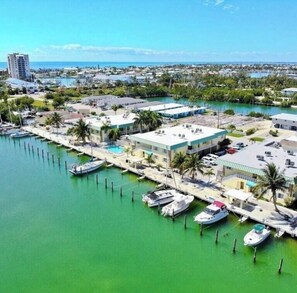 A marina with boats docked, a building with a flat roof, and a clear view of the ocean. - Beautiful 2-bedroom, 2-bath condo perfect escape to relax and fish in Marathon (Marathon)