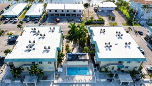 Un puerto deportivo con barcos amarrados, una piscina y dos edificios con una terraza de piscina.