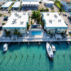A marina with boats docked, a swimming pool, and two buildings with a pool deck. - Beautiful 2-bedroom, 2-bath condo perfect escape to relax and fish in Marathon (Marathon)