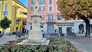 A statue in a public square with buildings in the background. - Una Finestra sul Lago by Interhome (Bellano)