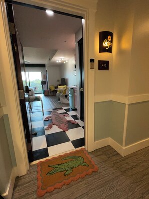 A hotel entrance with a checkered floor, a crocodile rug, and a room number sign. - Labor Day Opening🌴Last minute PCB Getaway  The Pink Panama at Origin at Seahaven (Panama City Beach)