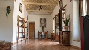 A hallway with a wooden door, a Buddha painting, a potted plant, and a cabinet. - Private Finca Alora pool & views near Málaga (Álora)