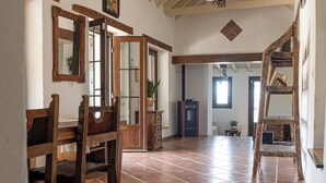 A spacious room with a high ceiling, wooden beams, a tiled floor, and a ceiling fan. - Private Finca Alora pool & views near Málaga (Álora)