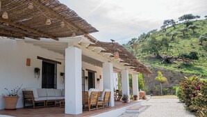 A covered outdoor seating area with a patio, a white building with columns, and a view of a hillside. - Private Finca Alora pool & views near Málaga (Álora)