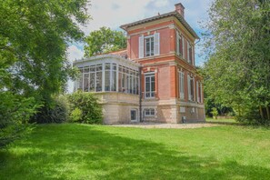 A two-story building with a glass conservatory, surrounded by lush greenery. - La Villa Coqueret - LUSIGNY SUR BARSE (LUSIGNY SUR BARSE)