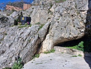 A rocky terrain with a stone pathway leading to a cave-like structure.