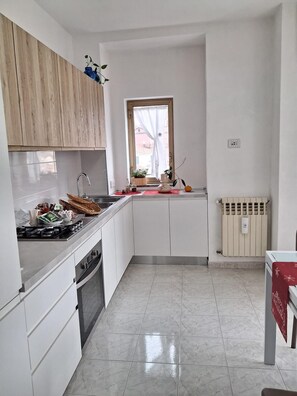 A modern kitchen with white cabinets, a stainless steel sink, and a window with a view.