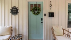 A teal door with a wreath, a 'Bird's Nest' sign, and the number 107 on the wall. - Walk to Downtown Jboro · Remodeled 3BR · Sleeps 6 (Jonesborough)