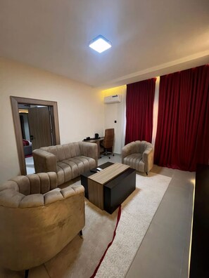 Una sala de estar moderna con un sofá seccional, una mesa de centro y una cortina roja.
