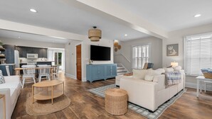Ein modernes Wohnzimmer mit einer Couch, einem Couchtisch und einem Fernseher.