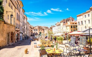 A cobblestone street lined with historic buildings, outdoor seating at cafes, and a clear blue sky. - T4 modern, bright and central with balcony Apartment in residence Toulon (Toulon)