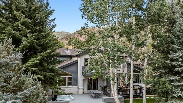 Une maison moderne dotée d’un patio, d’un espace salon extérieur et d’un jacuzzi.