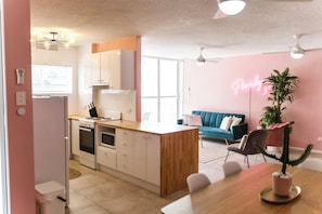 A modern kitchen with white cabinets, a wooden countertop, and a built-in oven. - Pink Paradise | 2 Min to Beach | Sleeps 5 (Surfers Paradise)