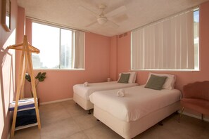 A room with two beds, a ceiling fan, and a window with blinds. - Pink Paradise | 2 Min to Beach | Sleeps 5 (Surfers Paradise)