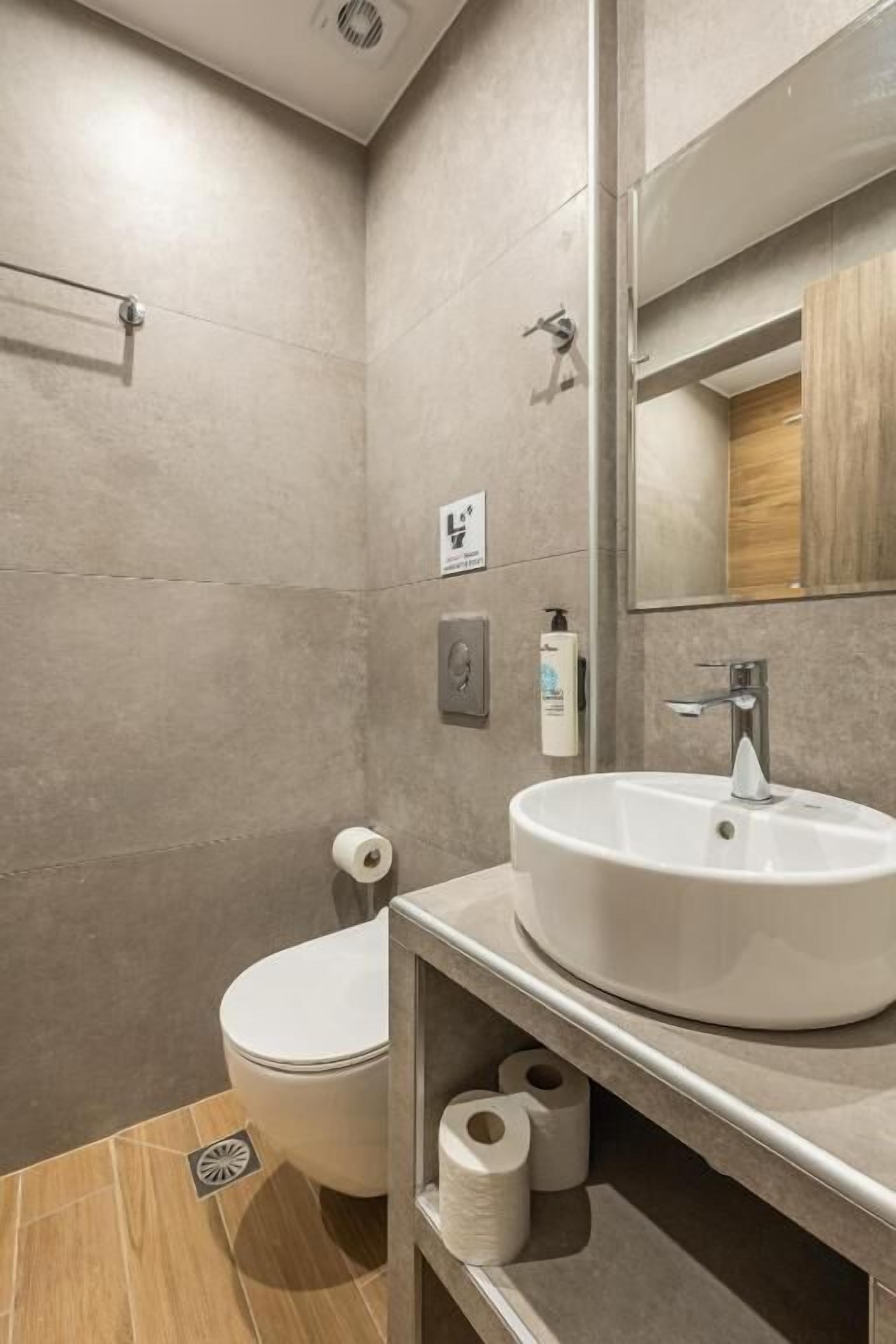 Moderni kylpyhuone, jossa on wc, pesuallas ja peili.