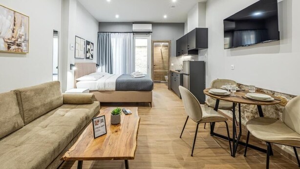 Eine moderne Wohnung mit Wohnbereich, Esstisch, Sofa, Bett und Küchenzeile.