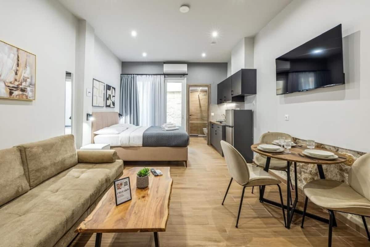 Un apartamento moderno con sala de estar, mesa de comedor, sofá, cama y cocina.