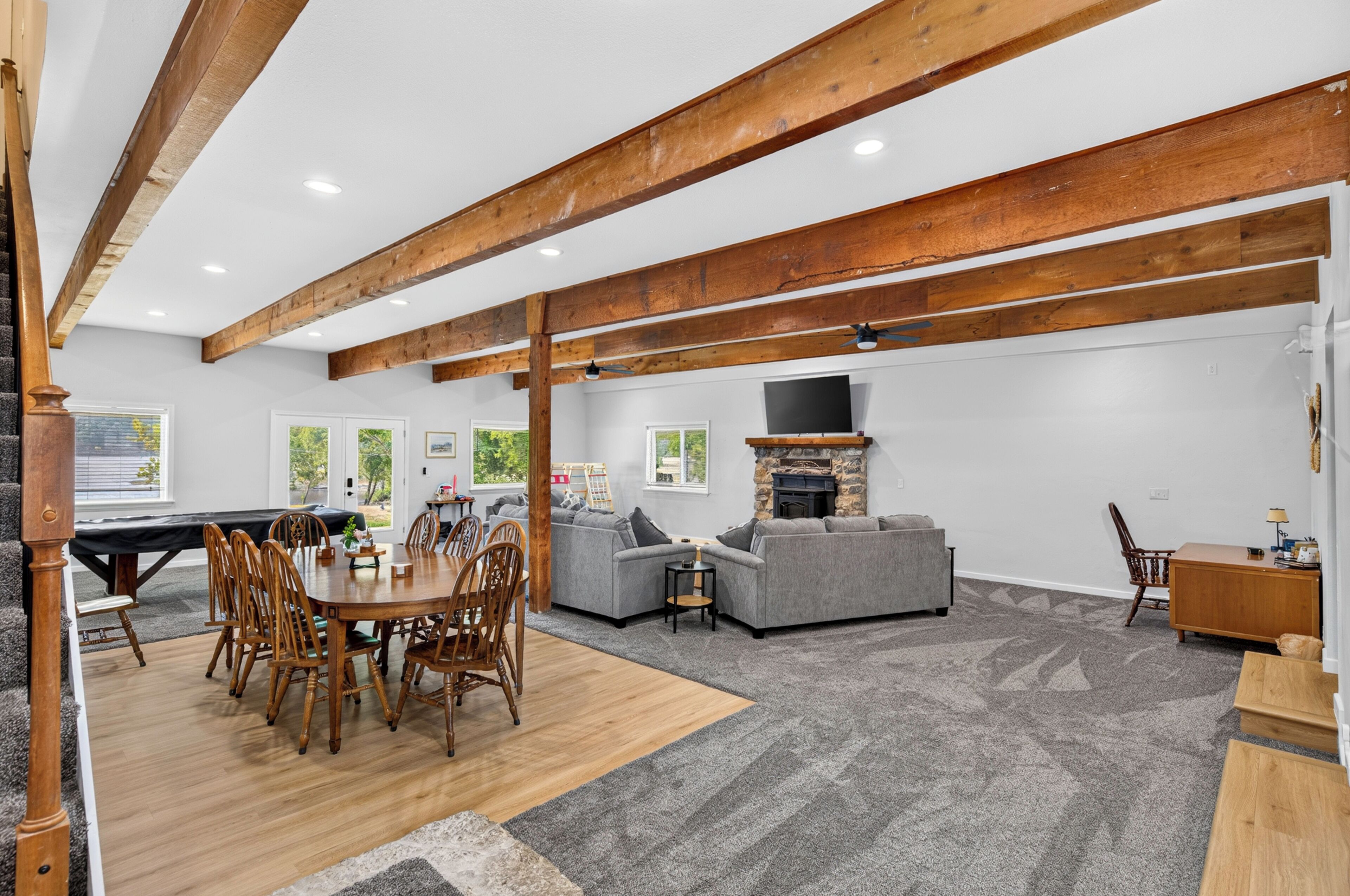 A spacious living area with a dining table, sofas, and a fireplace.