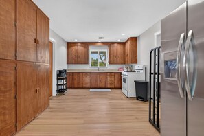 A kitchen with wooden cabinets, a stainless steel refrigerator, and a window. - The Overlook at Hidden Cove - newly listed property on the lake with dock (Fairland)