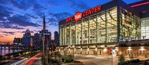 Un KFC Yum! Center doté d’une façade en verre, d’une grande enseigne et offrant une vue sur les gratte-ciel de la ville en arrière-plan.