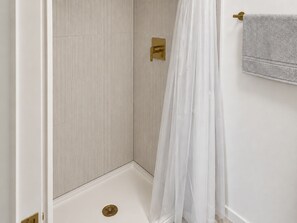 A shower area with a white shower curtain and a gold shower control panel. - Downtown! 4th Street, Brown Theatre, KFC Yum! (Louisville)