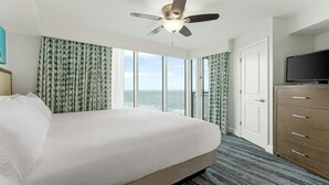 Ein Hotelzimmer mit Bett, Deckenventilator, Fernseher und Meerblick.