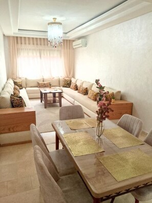 A modern living room with a sofa set, dining table, and a chandelier. - appartement chic en plein centre (Marrakesh)
