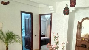 A dining area with a table, chairs, a vase with flowers, a potted plant, and a mirror. - appartement chic en plein centre (Marrakesh)