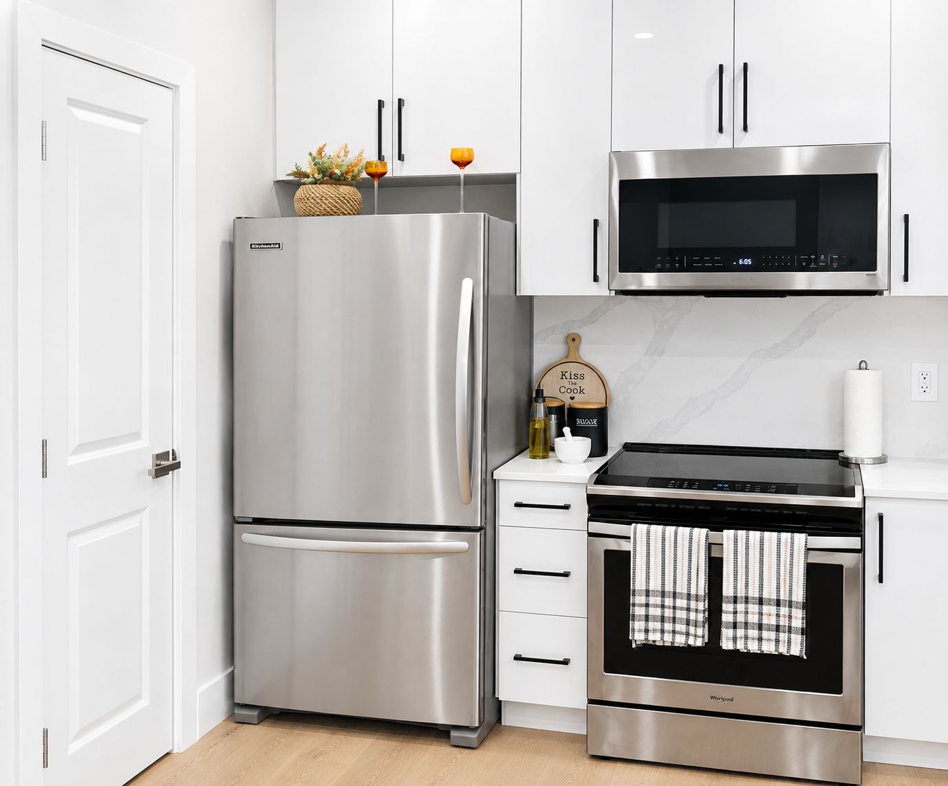 Una cocina moderna con un refrigerador de acero inoxidable, microondas y horno.