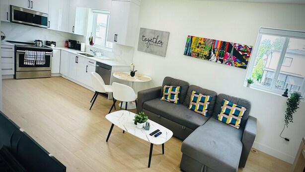 A modern living space with a kitchen, dining area, and a sofa set. - Fully AC 2 Bed 2 Bath Apartment (Surrey)