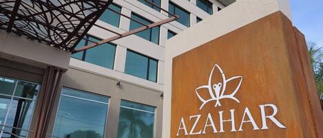 A building with a sign for 'AZAHAR HOTEL & SPA' featuring a lotus flower logo.